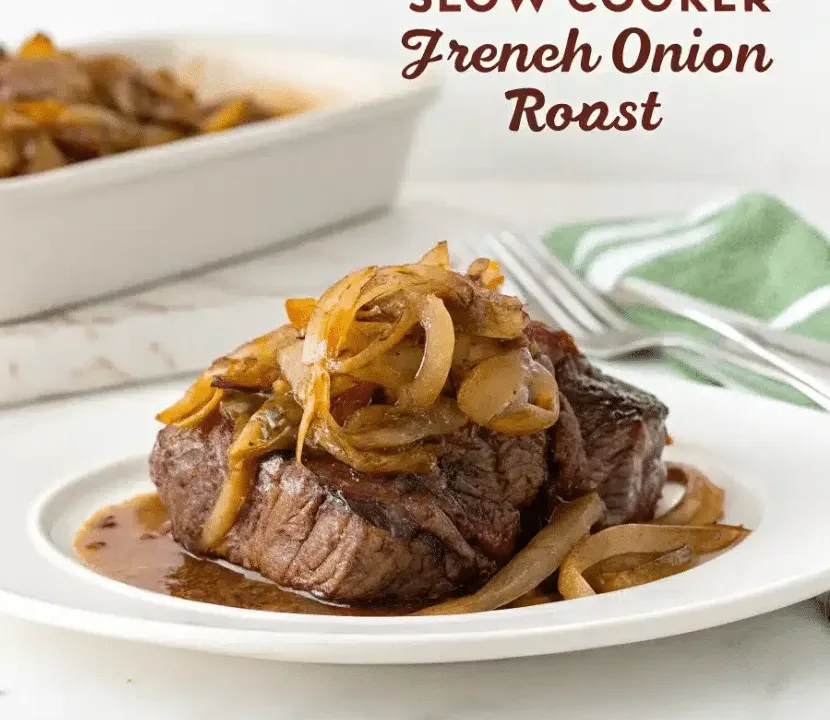A thick piece of pot roast on a white plate, piled with golden caramelised onions and sitting in a pool of dark onion jus, with a serving dish and fork behind it.